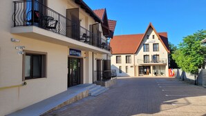 A street with a building labeled "LOTUS BOUTIQUE" and another building with a sign "VillaLotus". - Villa Lotus (Deva)