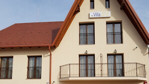 A two-story building with a sign reading "Villa Lotus." It features a balcony with metal railings and large windows. - Villa Lotus (Deva)