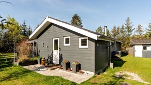 A single-story house with a grey exterior, a white door, and a small attached garage.