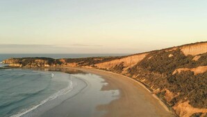Eine Küstenlandschaft mit Strand, Klippen und dem Meer.