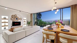 A modern living room with a large TV, a sofa, and a dining area with a wooden table and chairs.