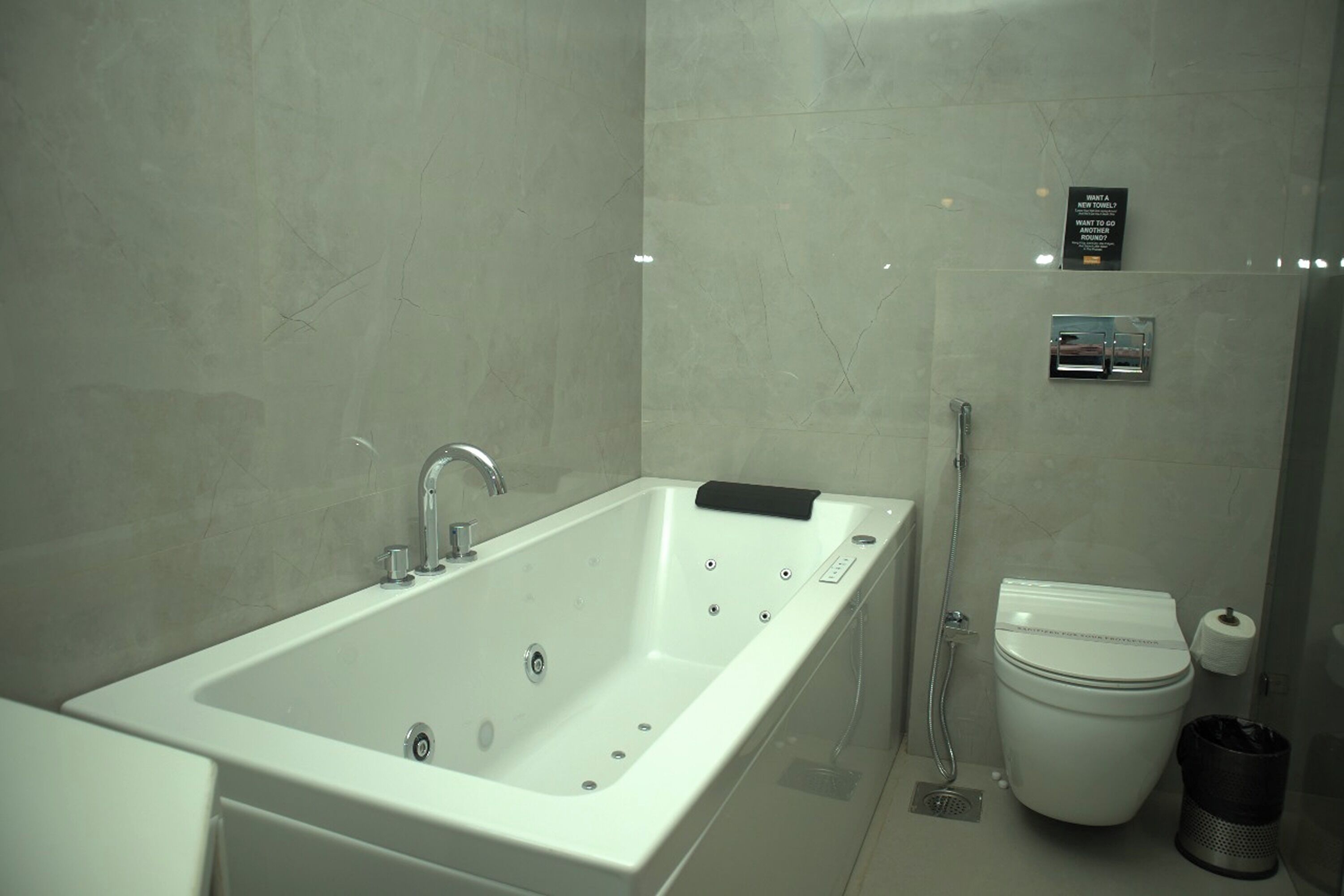 A modern bathroom with a large bathtub, a toilet, and a shower area.