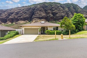 A residential house with a garage, a driveway, and a fire hydrant. - Pakele Oahu by AvantStay | 5 Min to Makaha Beach (Waianae)