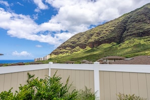 Un quartier résidentiel avec des maisons, une clôture blanche et une montagne en arrière-plan.