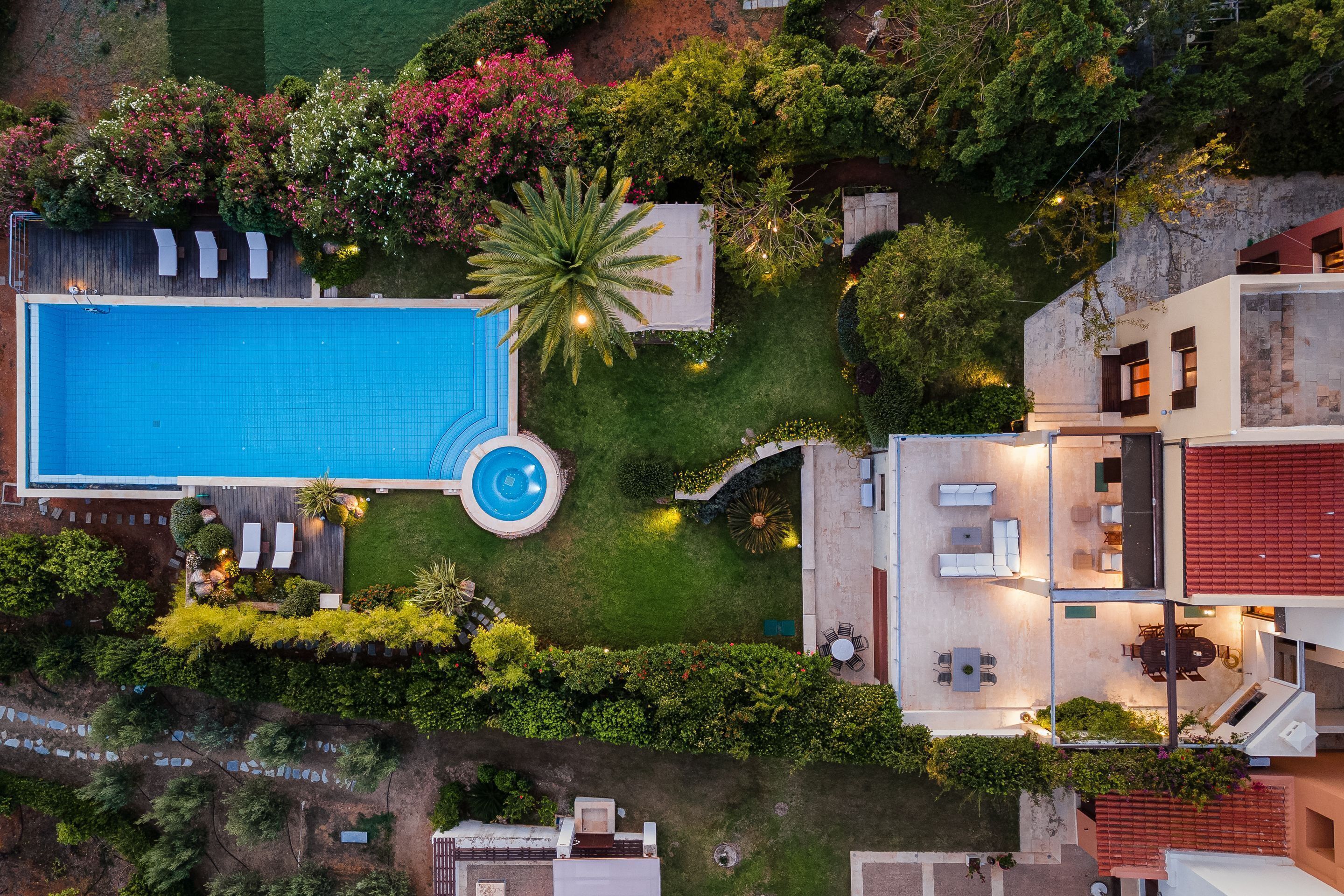 Eine Luftaufnahme eines Wohnhauses mit Swimmingpool, Sitzgelegenheiten im Freien und einem gepflegten Garten.
