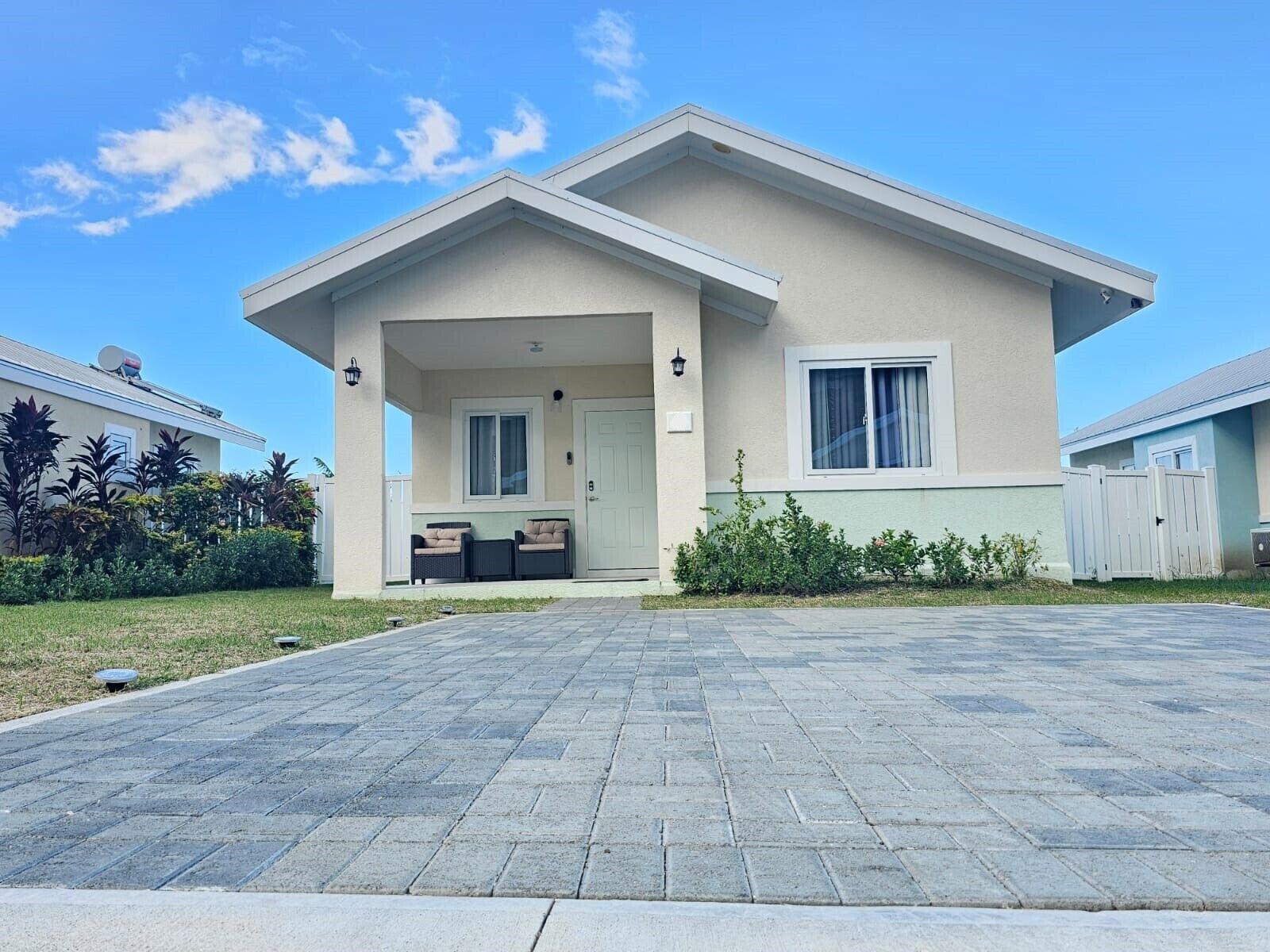 A two-story house with a covered porch, a front door, and a window.
