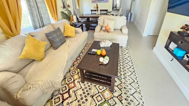 Un salon comprenant un canapé, une table basse et un coin repas avec une table et des chaises.