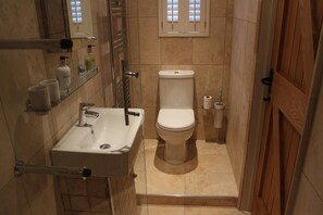 A compact bathroom with a sink, toilet, and a small window. - Lovely 1-bed Cottage in Rural Cowbeech Hailsham (Hailsham)