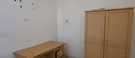 Une pièce avec un bureau en bois et une armoire.