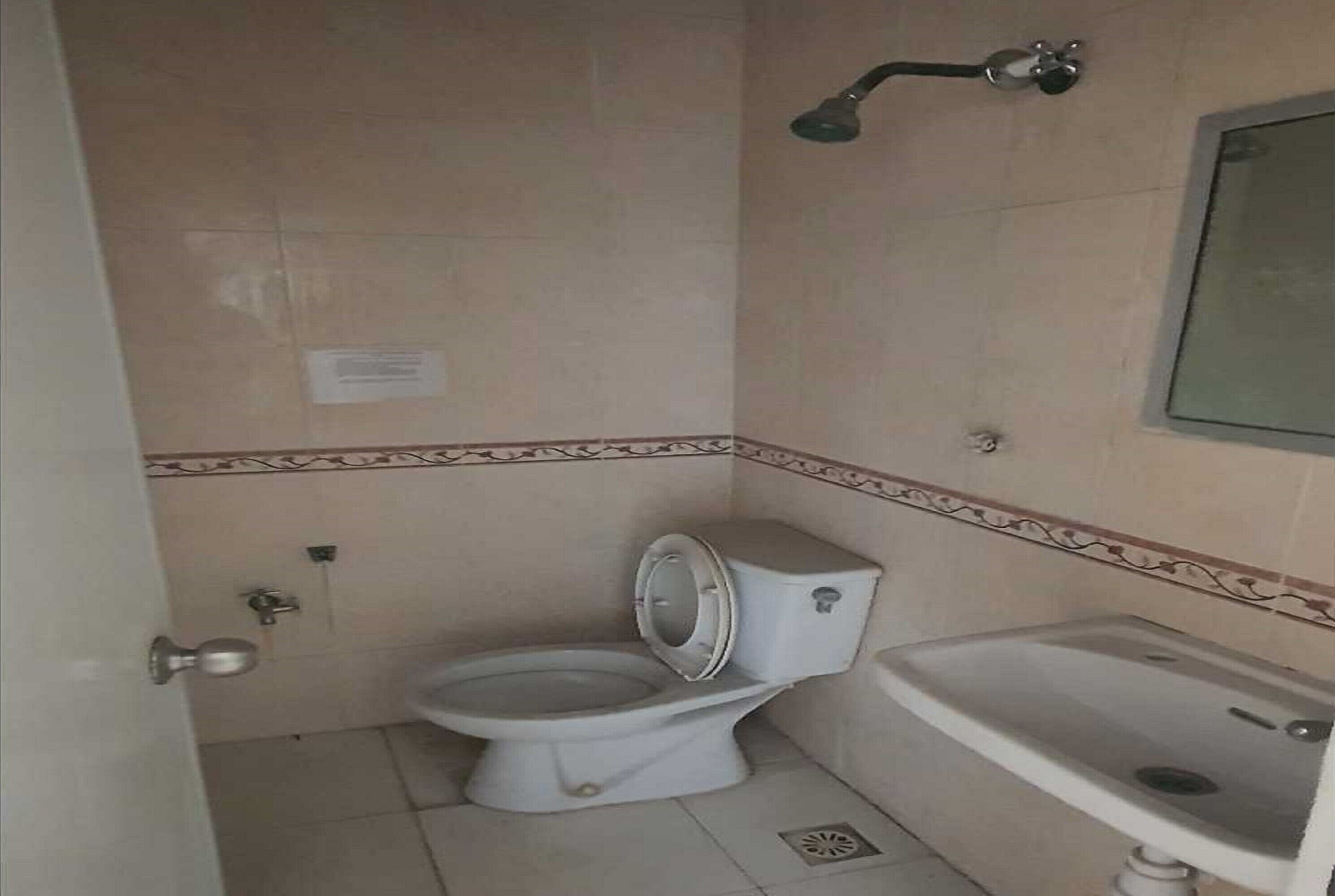 Un baño pequeño con inodoro, lavamanos y ducha.