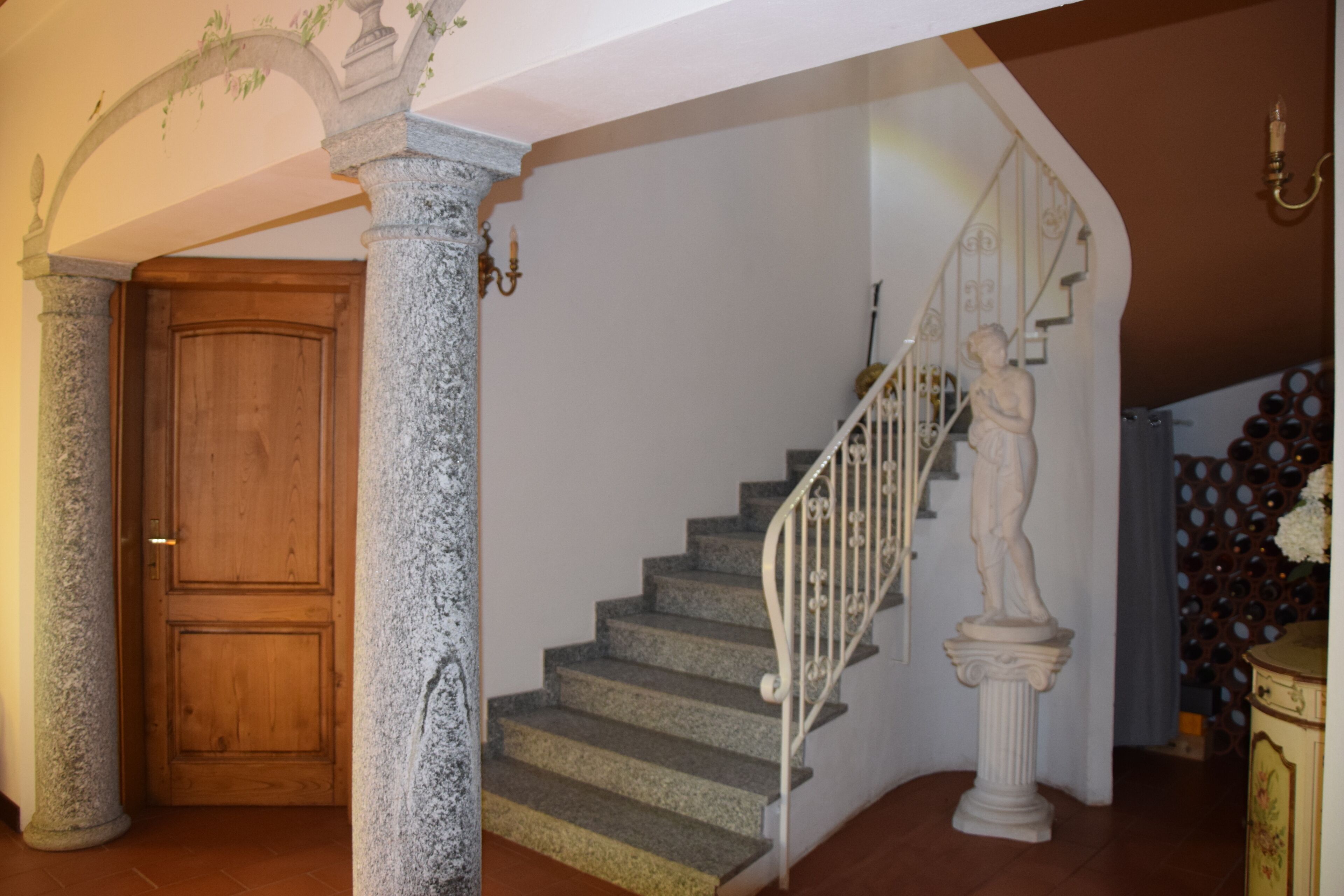 A staircase with stone columns and a wooden door at the base.