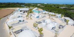 A resort with dome-shaped accommodations, a central building labeled "HEAVEN," and a surrounding landscaped area with palm trees.