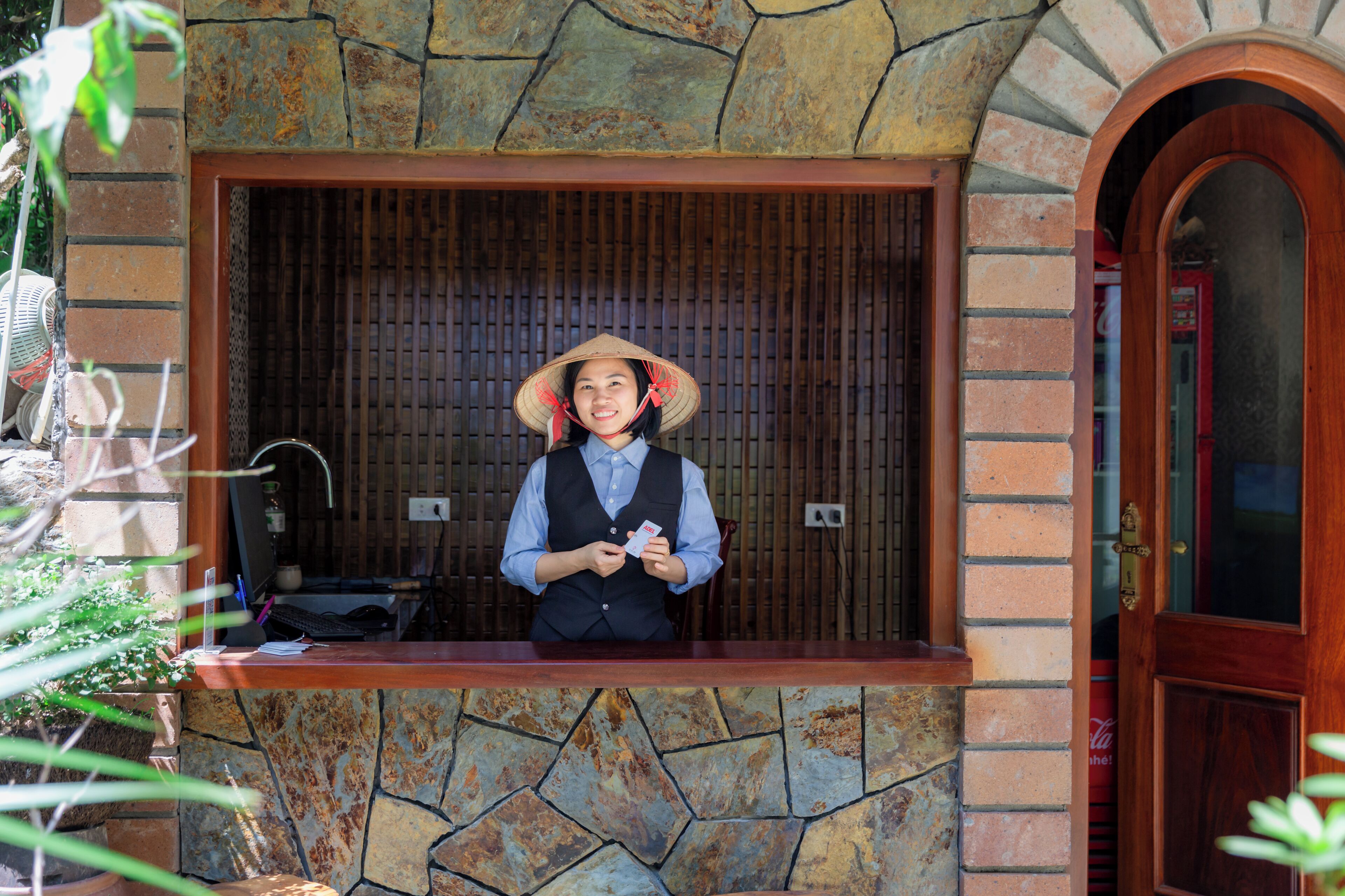 A reception desk with a stone facade, a wooden door, and a computer monitor.