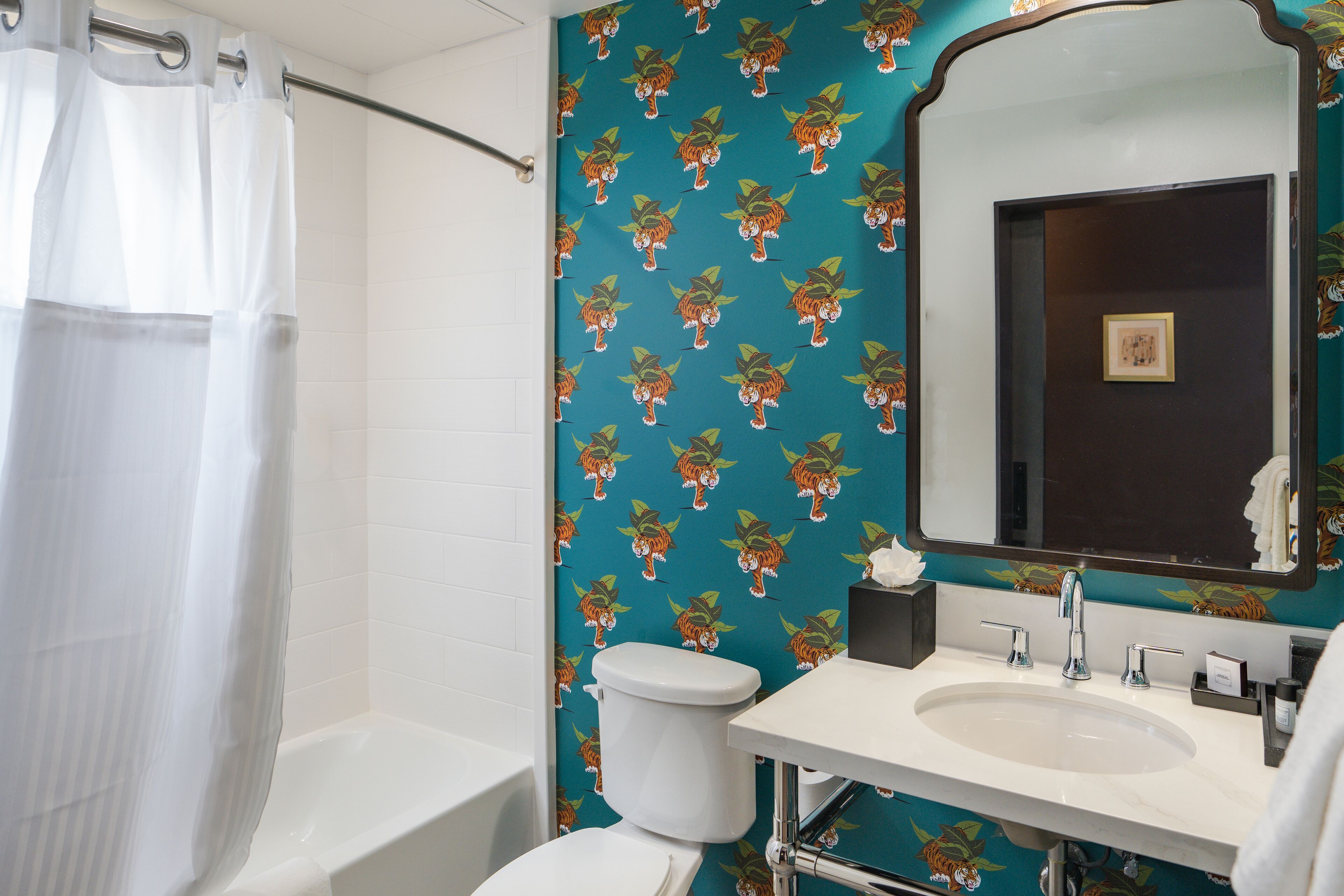 A bathroom with a white bathtub, a toilet, and a sink with a mirror.