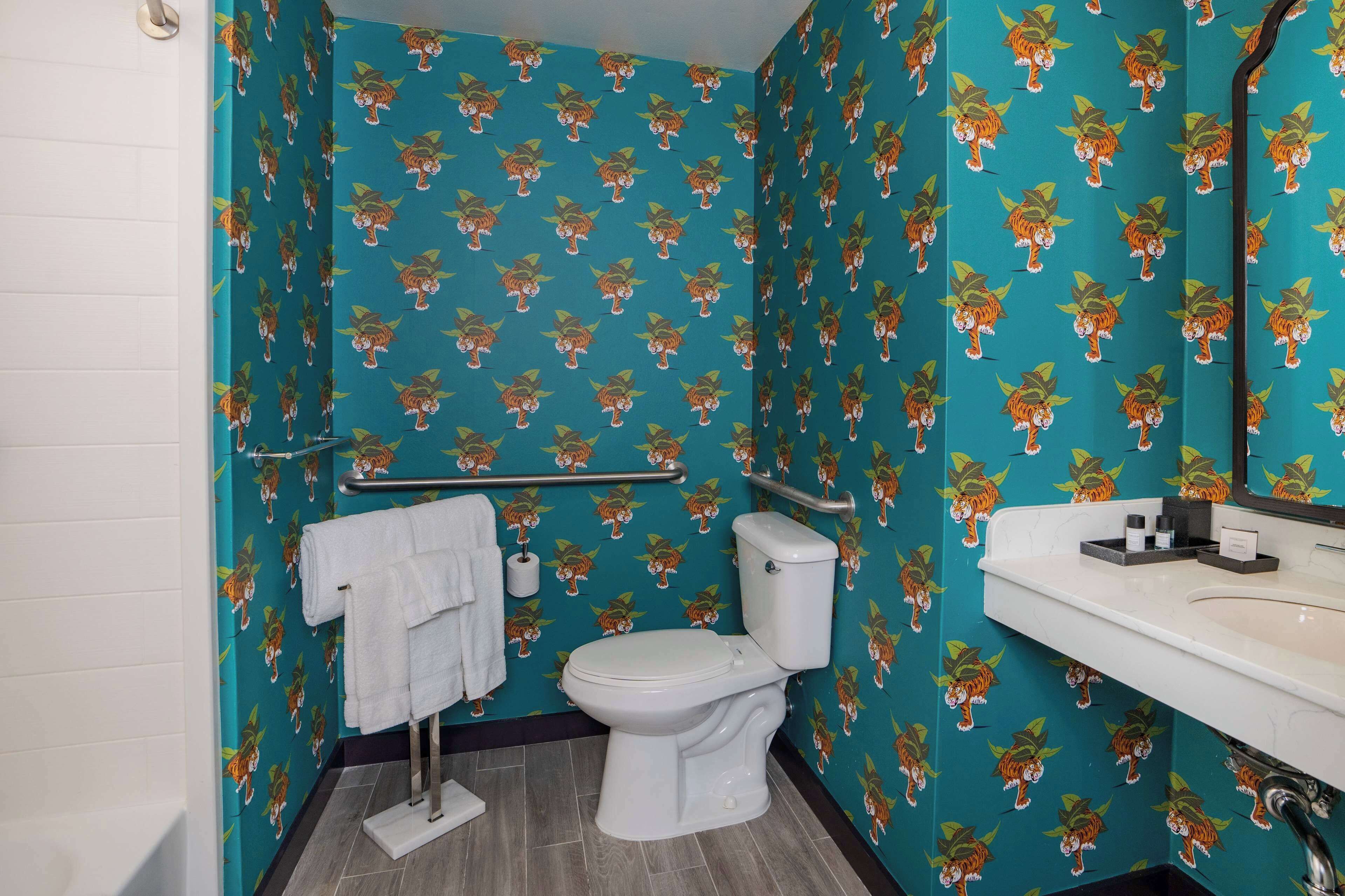 Un baño con inodoro, lavamanos y barra para toallas.