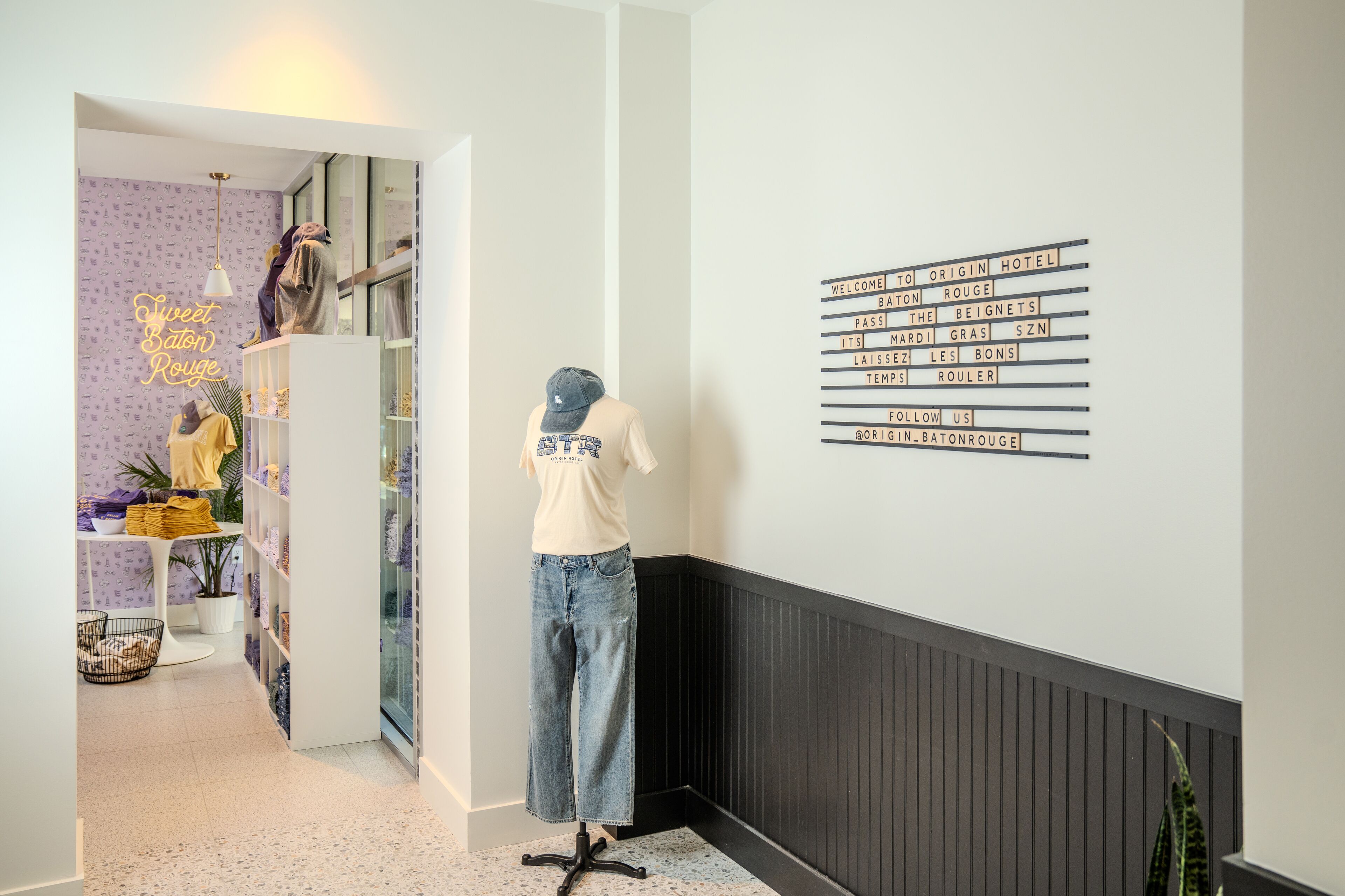 A mannequin in a hallway with a sign listing hotel amenities.