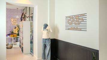 A mannequin in a hallway with a sign listing hotel amenities.
