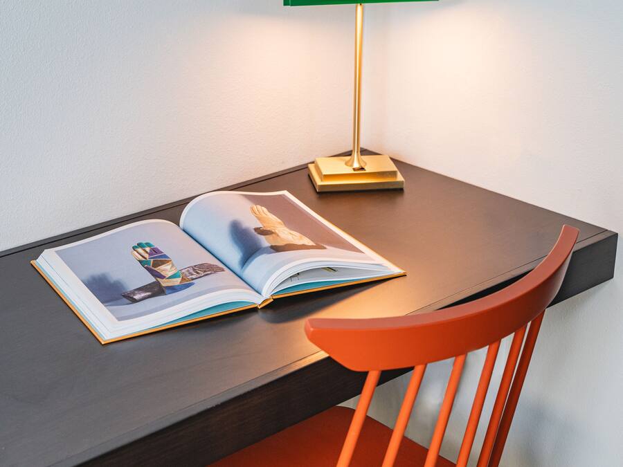 A desk with a book and a lamp.
