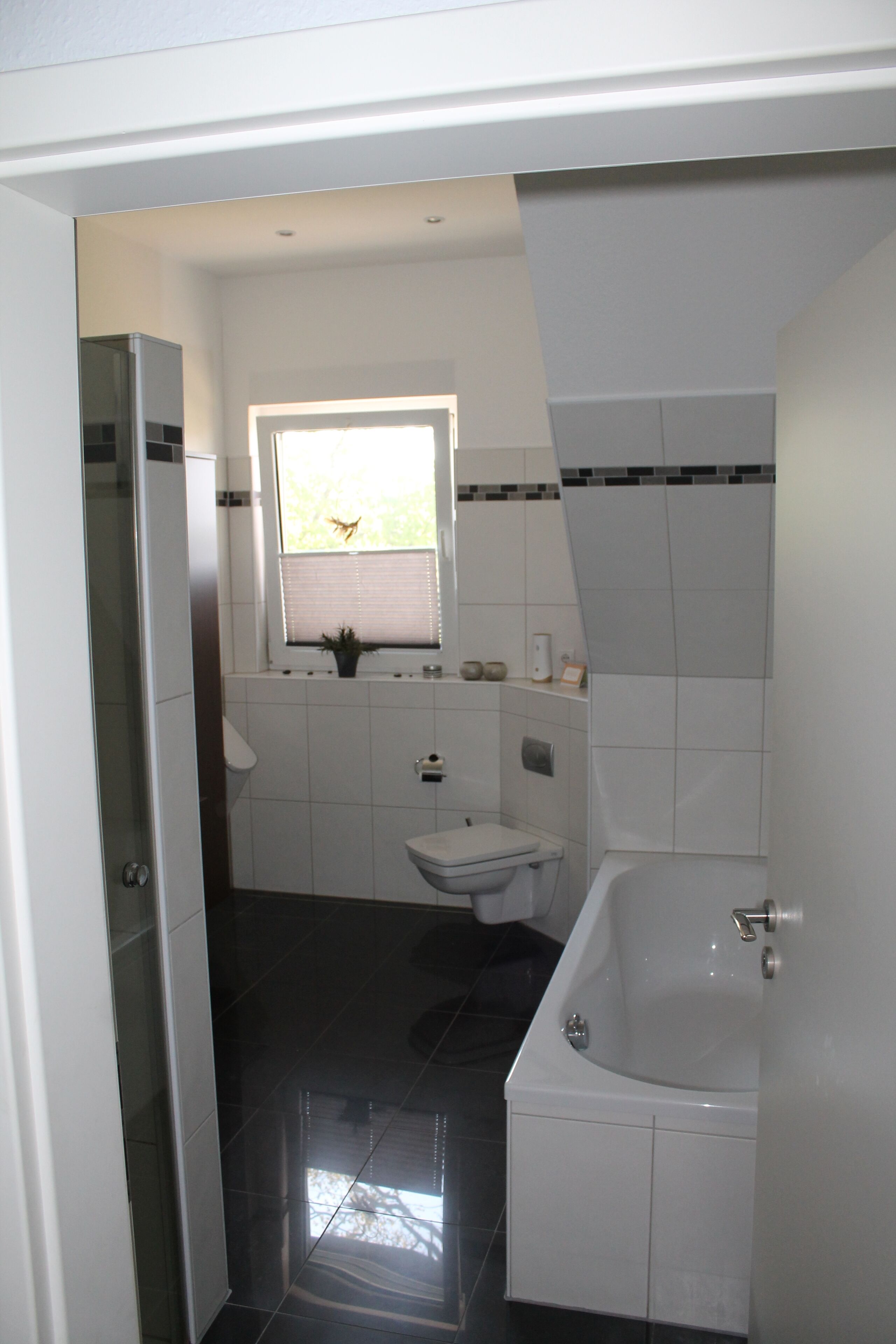 A modern bathroom with a toilet, sink, and bathtub.