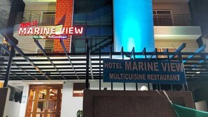 Ein modernes Hotel mit einem gut sichtbaren Schild, auf dem 'MARINE VIEW HOTEL MULTICUISINE RESTAURANT' steht.