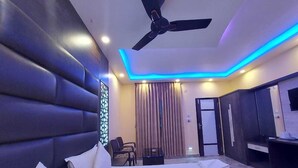 Ein modernes Hotelzimmer mit einem großen Bett, einem Deckenventilator und stimmungsvoller Beleuchtung.