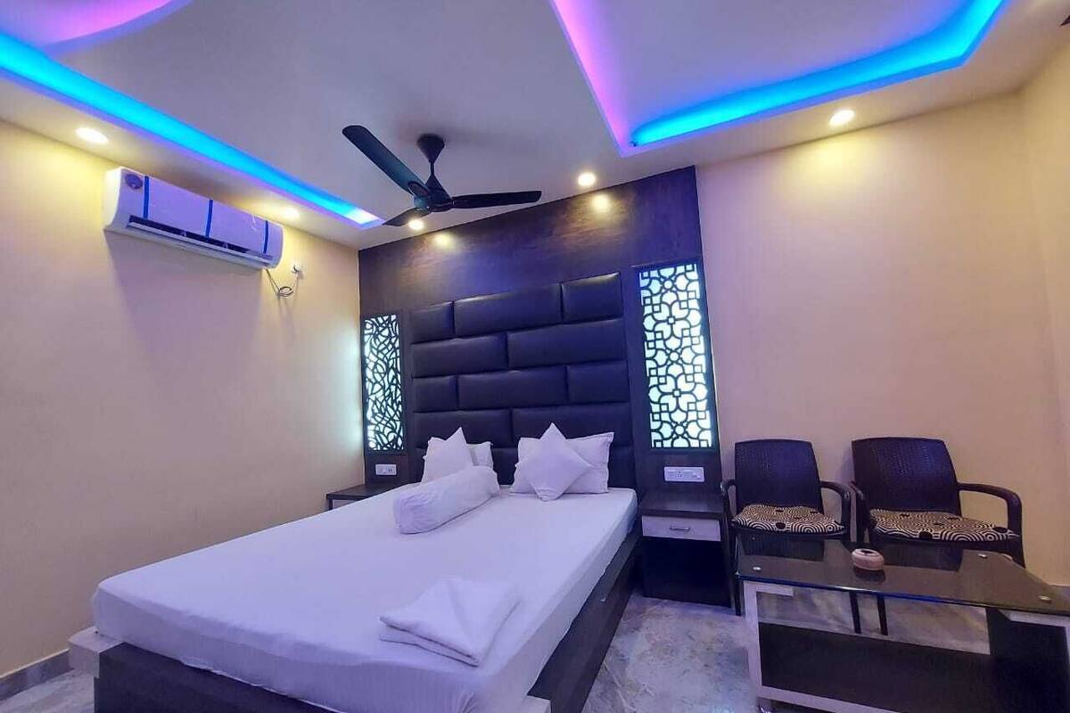 A modern hotel room with a large bed, a ceiling fan, and a desk with two chairs.