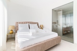 A modern bedroom with a large bed, bedside lamps, and a glass shower enclosure. - Villa Aurum ZadarVillas (Zadar)