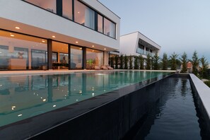 Une maison moderne dotée d’une piscine et d’un espace patio.