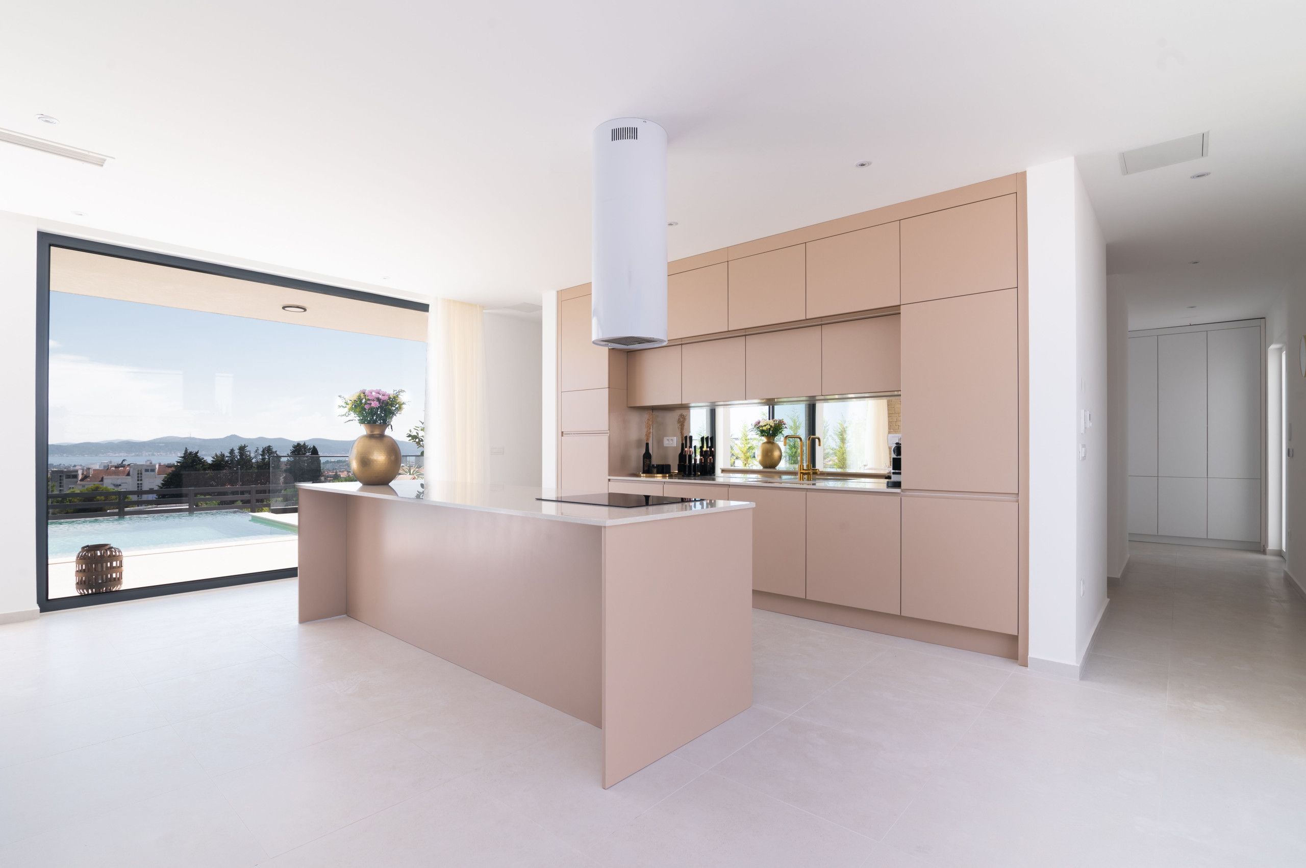 Una cocina moderna con una isla central, ventanas amplias y vistas al exterior.