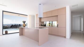 Una cocina moderna con una isla central, ventanas amplias y vistas al exterior.