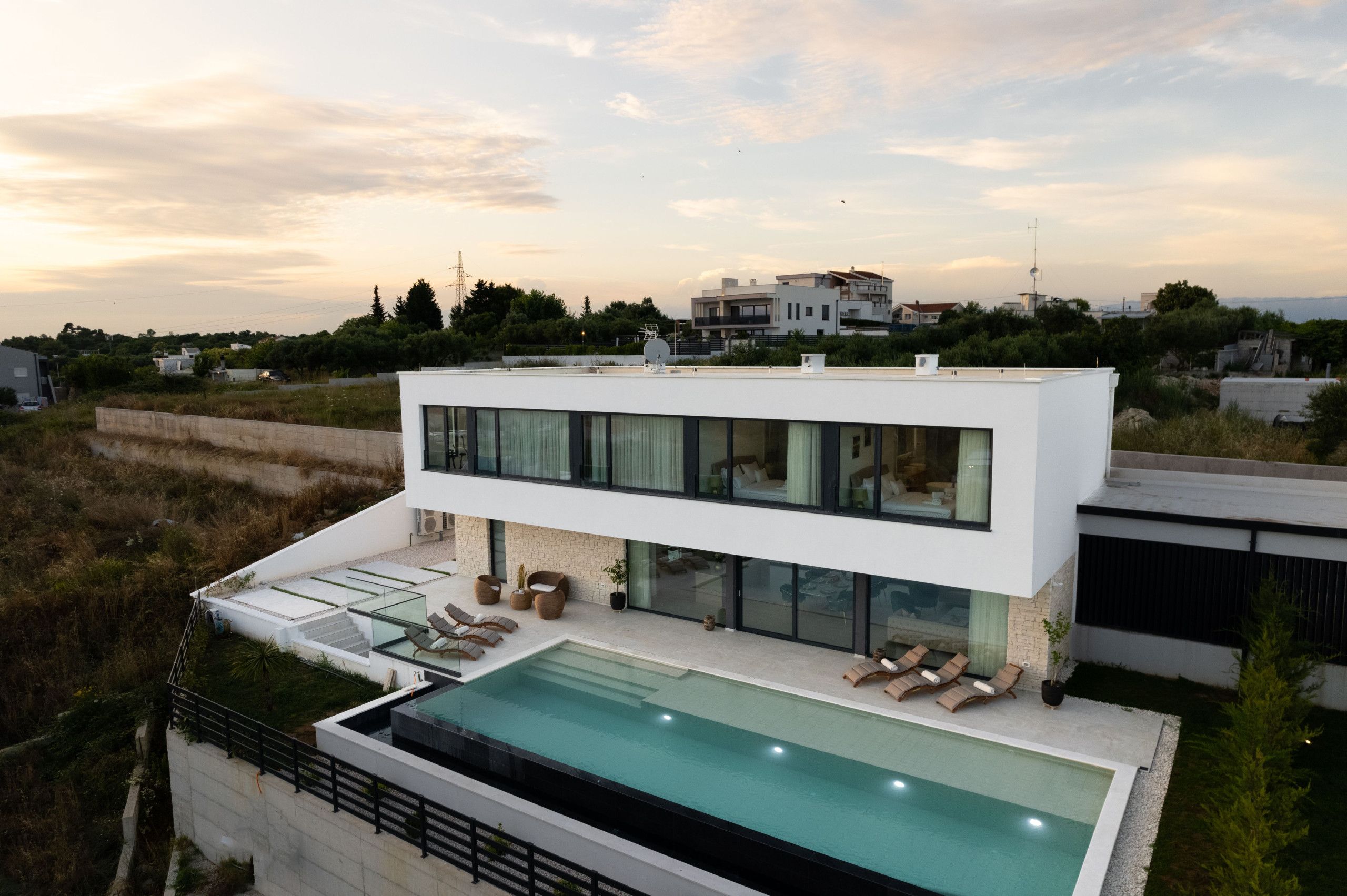Una casa moderna con piscina en la azotea, amplios ventanales y vistas al paisaje circundante.