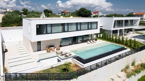 A modern two-story house with a swimming pool, outdoor seating, and a well-maintained garden. - Villa Aurum ZadarVillas (Zadar)