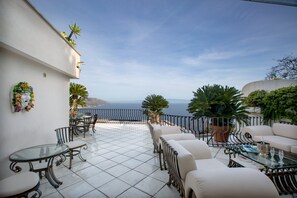 A terrace with outdoor seating and a view of the sea. - Breathtaking views in a quiet part of Taormina, just a stone's throw from downtown (Taormina)