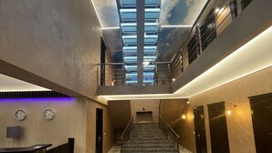 A spacious lobby with a marble floor, a staircase, and a ceiling with skylights. - Pensiunea Ramina (Adjud)