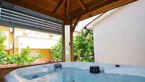 A hot tub under a wooden pergola with a view of a residential area. - Holiday house in Medulin, 150m from the beach (Medulin)