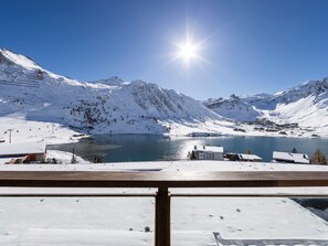 A snow-covered mountain landscape with a lake, buildings, and a clear sky. - Charming renovated apartment for 4 in Tignes with lake view (Tignes)