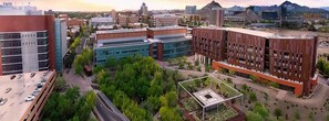 A modern urban campus with multiple buildings, a central plaza, and a parking area.