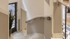A staircase with a handrail, a wall-mounted light, and a framed picture. - Acropolis Maisonette 22 (Athina)