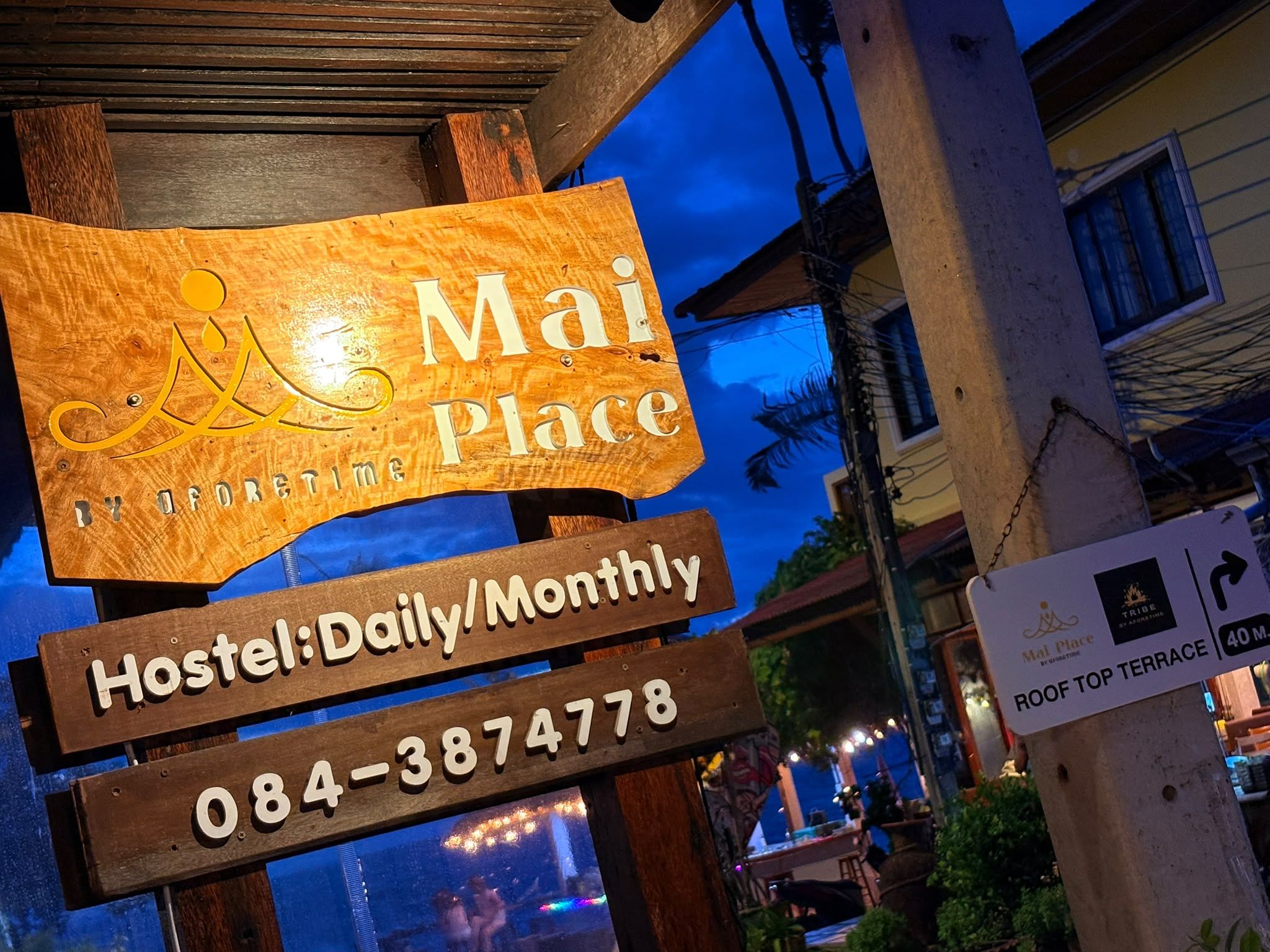 Een hostelbord met de naam 'Mai Place' en contactgegevens.