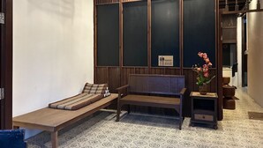A room with a wooden bench, a small table, and a potted plant. - MAI Place by Aforetime (Koh Samui)