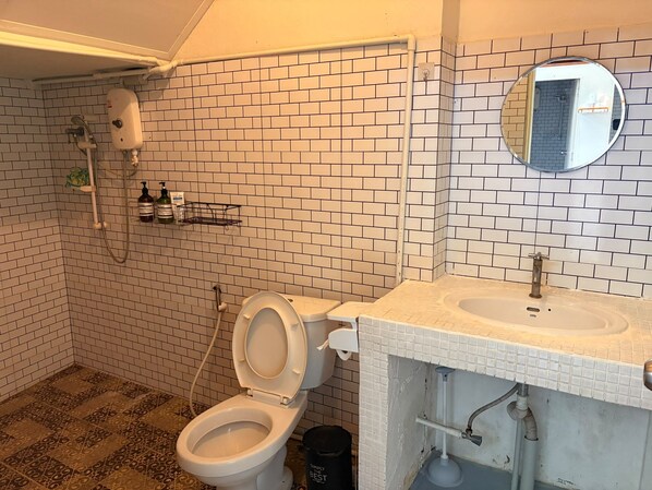 A bathroom with a toilet, sink, and shower.