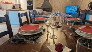 Een eettafel gedekt voor een maaltijd, compleet met wijnglazen, borden en bestek.