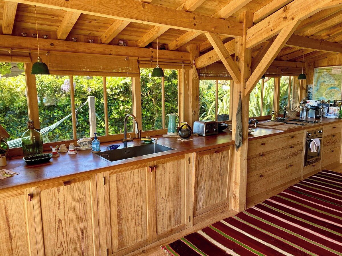 Una cocina de madera con un ventanal grande, un lavabo y una estufa.