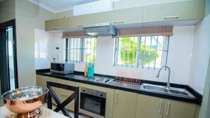 A modern kitchen with a microwave, stove, oven, and sink.