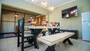 A modern dining area with a table and chairs, a bench, and pendant lighting.