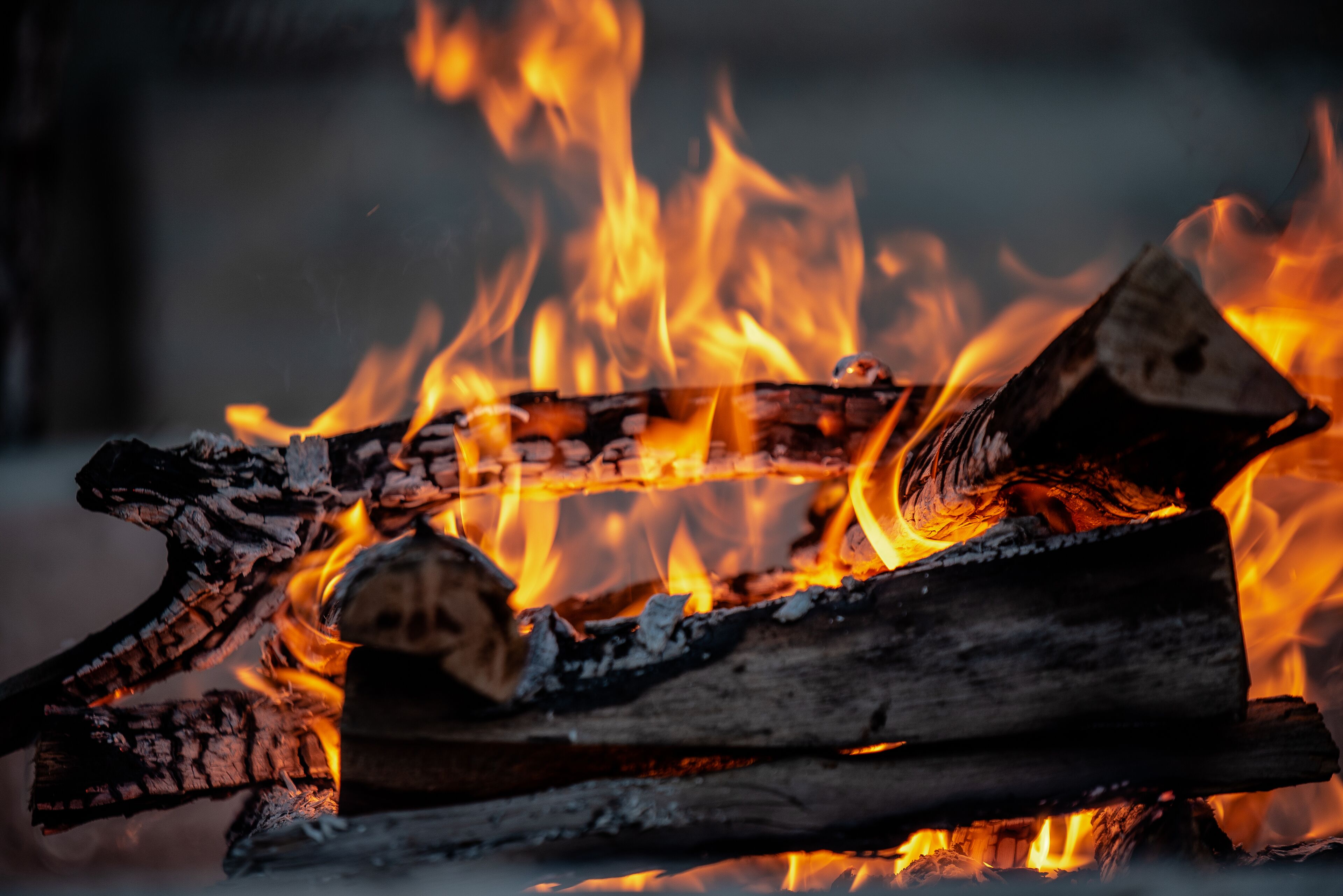 A close-up of burning logs with bright flames.
