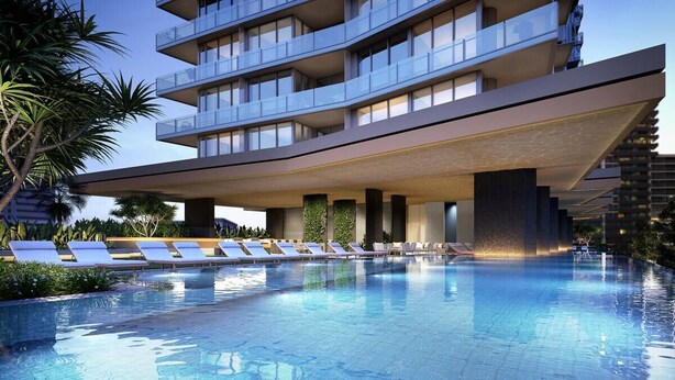 A modern hotel with a rooftop infinity pool, lounge chairs, and a view of the surrounding area. - Luxury Signature Stay Ocean Views 2BR Lvl 9 (Broadbeach)