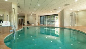 An indoor swimming pool with clear water, tiled walls, and ceiling lights. - Hotel Altos de Istán (Istan)