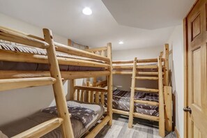 A room with bunk beds, a wooden door, and a ceiling light. - Pine Bay Lodge - Lakefront (Wisconsin Dells)