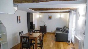 Een eethoek met een houten tafel en stoelen, een bank en een radiator.